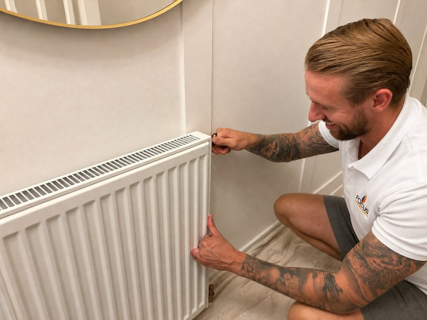 A Focus Plumbing & Heating engineer fitting a radiator