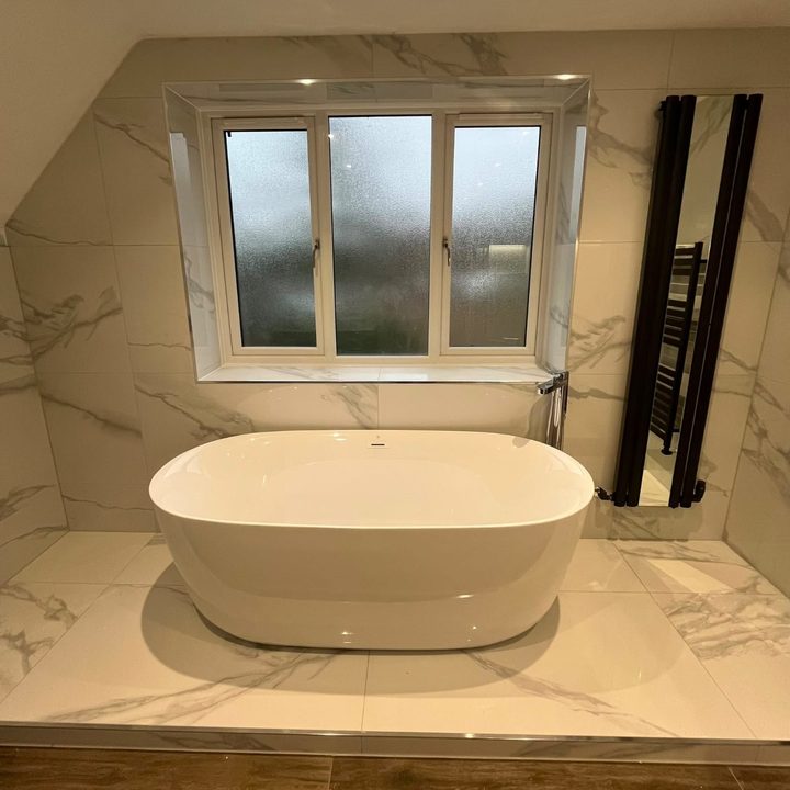 Freestanding bath in a marble-tiled bathroom